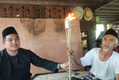 Mohd Redzuan Zainal (kiri) dan Zainuddin Ismail (kanan) menunjukkan jamung yang sering digunakan masyarakat zaman dahulu.