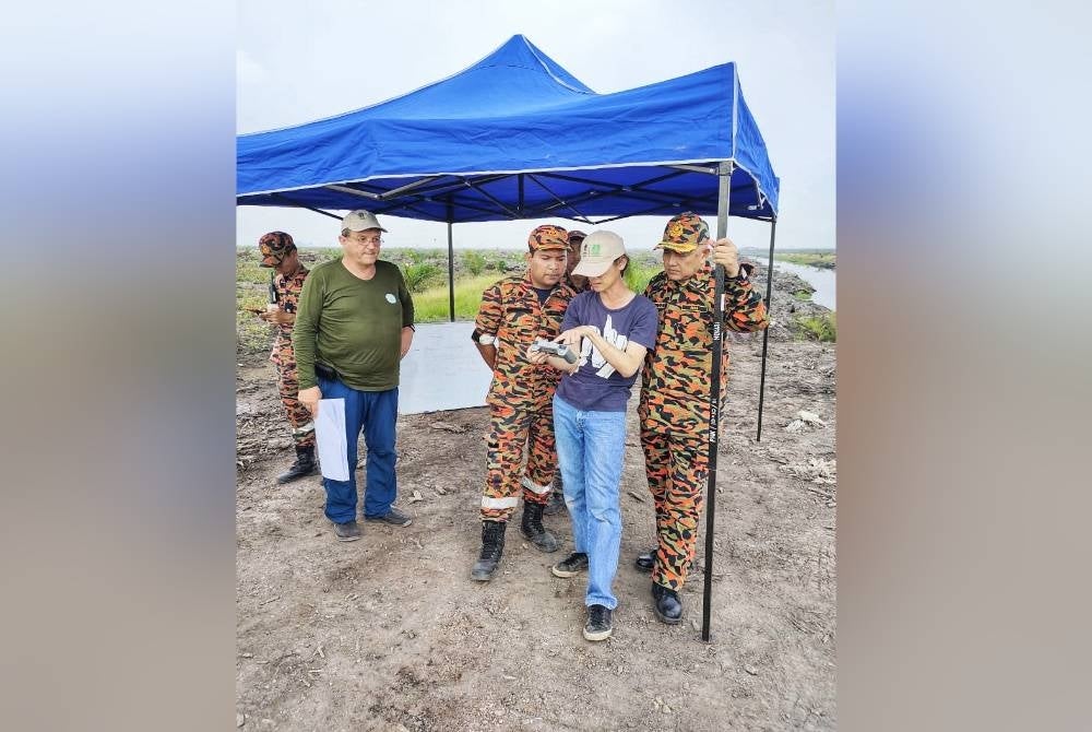 Wan Mohammad (kanan) ketika melihat hasil rakaman dron yang dilakukan oleh NGO yang turut membantu dalam operasi tersebut. - Foto Bomba