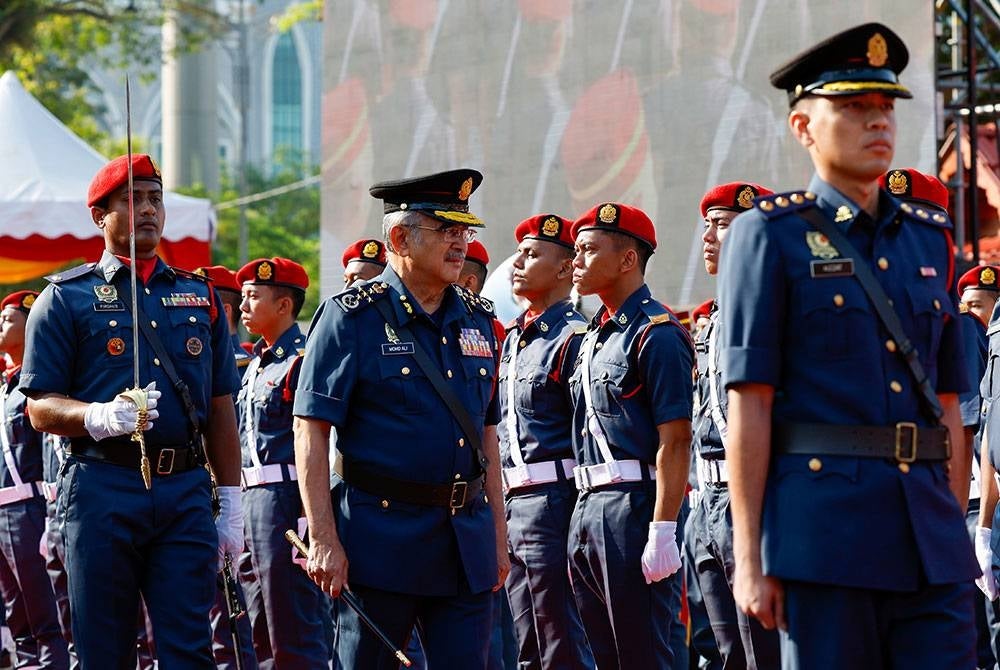 Yang Dipertua Negeri Melaka Tun Mohd Ali Rustam (tengah) melakukan pemeriksaan kawalan kehormat bomba pada Sambutan Hari Bomba Sedunia di Memorial Pengisytiharan Kemerdekaan dekat Banda Hilir hari ini.