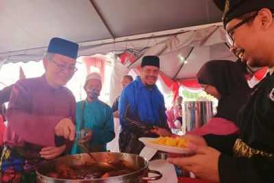 Harith Fadzilah (tiga dari kiri) bersama Dr Fadzli Cheah (kiri) menyantuni orang ramai yang hadir dalam majlis Sambutan Hari Raya Masjid Muhammadiah (Masjid Cina) di Taman Tasek Jaya, Ipoh pada Ahad.