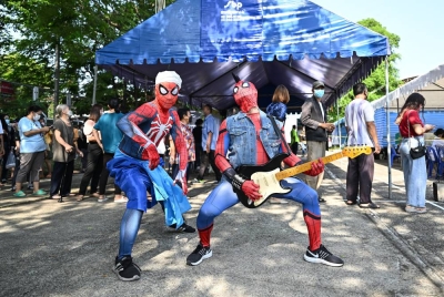 Gelagat dua lelaki memakai pakaian adiwira Spiderman mengadakan persembahan di luar pusat undian di Bangkok. - AFP