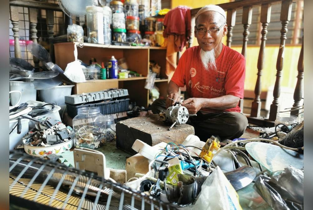 Hamid sedang membaiki kipas pelanggan ketika ditemui di Kampung Gong Kemunting, Kuala Ibai, di Kuala Terengganu.