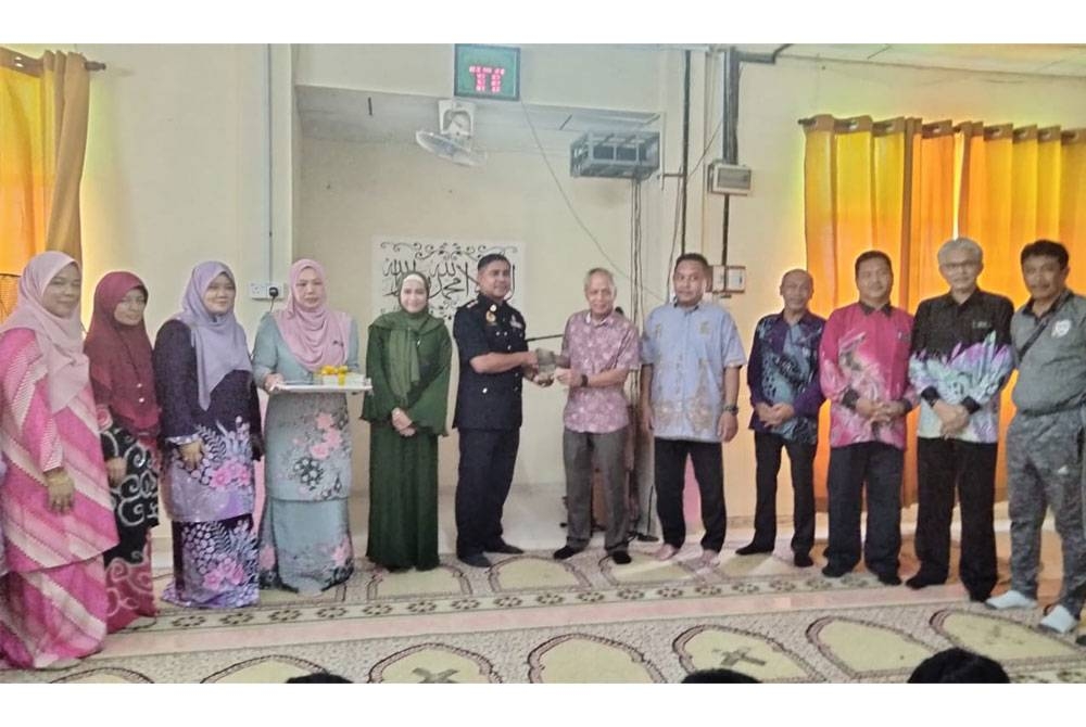 Sanusi (lima dari kiri) menyampaikan cenderahati kepada Mohd Nasir.