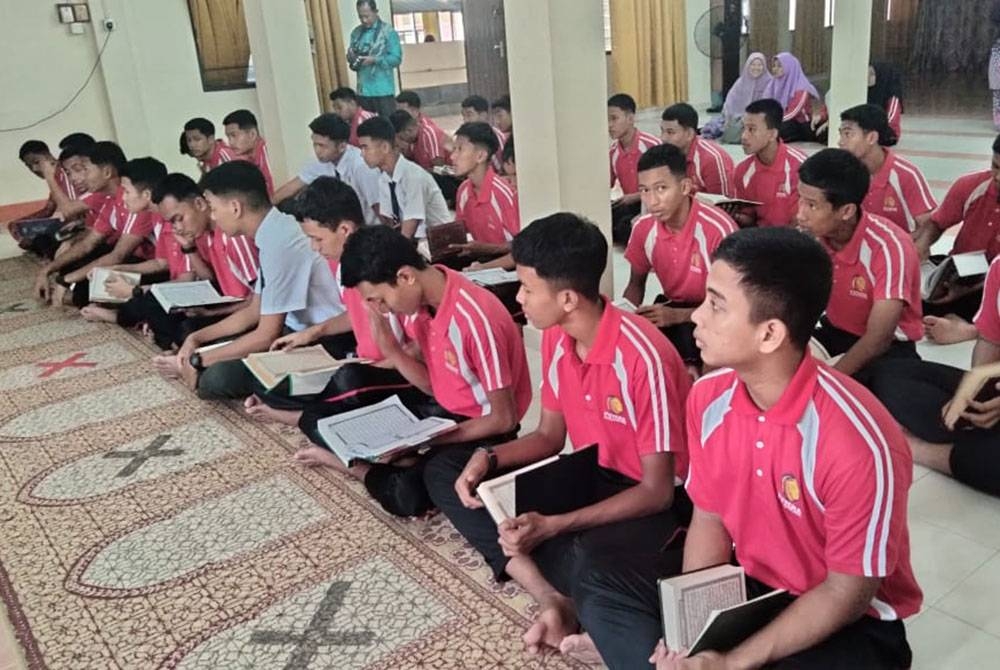 Pelajar turut membaca al-Quran sempena Majlis Penyampaian Sumbangan Al-Quran di SMK Putera.
