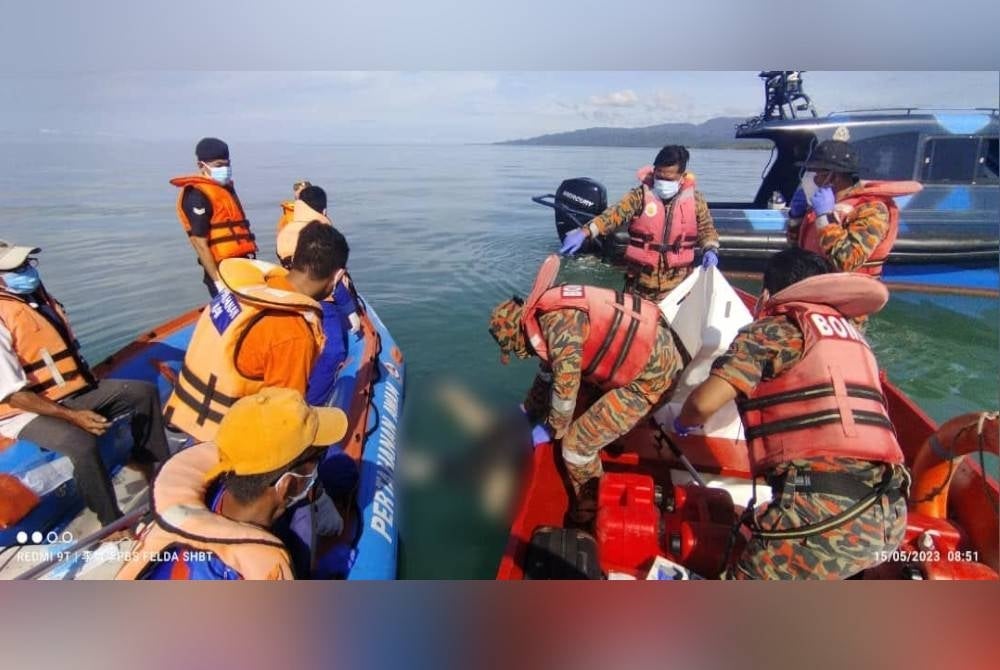 Mayat mangsa cuba dibawa naik oleh pasukan bomba di perairan Kampung Nala Lama Tungku, Lahad Datu.