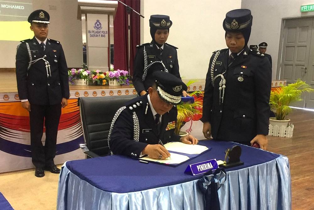 Kama Azural (kiri) menandatangani surat serah terima tugas pada Isnin.