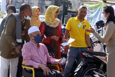 Seorang pengundi berkerusi roda tiba untuk membuang undi di sebuah pusat mengundi di Pattani, Thailand. - Foto Bernama
