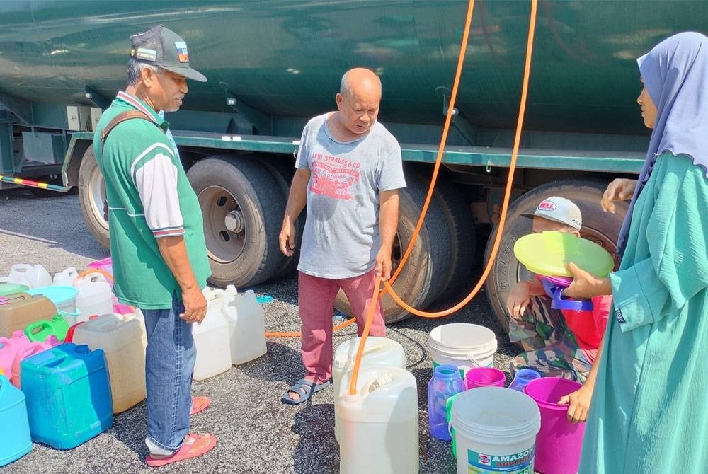 Mohd Azman (tengah) mengisi air untuk dibawa pulang ke rumah bagi memastikan keperluan harian tidak terganggu berikutan bekalan air terputus sejak Ahad.