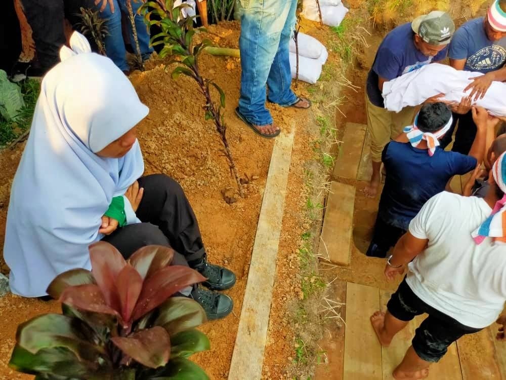 Siti Nur Khadijah sayu mengiringi pengkebumian ibu dan empat adik beradiknya di Tanah Perkuburan Islam Kampung Paya Panjang, Padang Rengas pada Selasa.