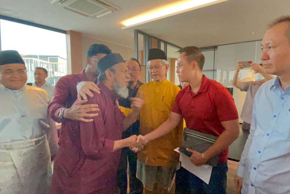 Alex (dua dari kanan) bersalaman dengan Muhammad Nasir sambil diperhatikan Ahmad Zakiyuddin (tiga dari kanan) selepas sidang akhbar pada Selasa.