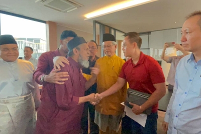 Alex (dua dari kanan) bersalaman dengan Muhammad Nasir sambil diperhatikan Ahmad Zakiyuddin (tiga dari kanan) selepas sidang akhbar pada Selasa.