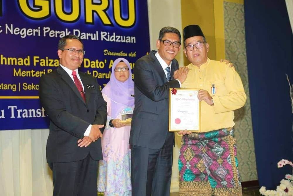 Azizan bersama bekas Ahmad Faizal yang pernah menjadi anak didiknya sempena sambutan Hari Guru peringkat negeri pada 2018.
