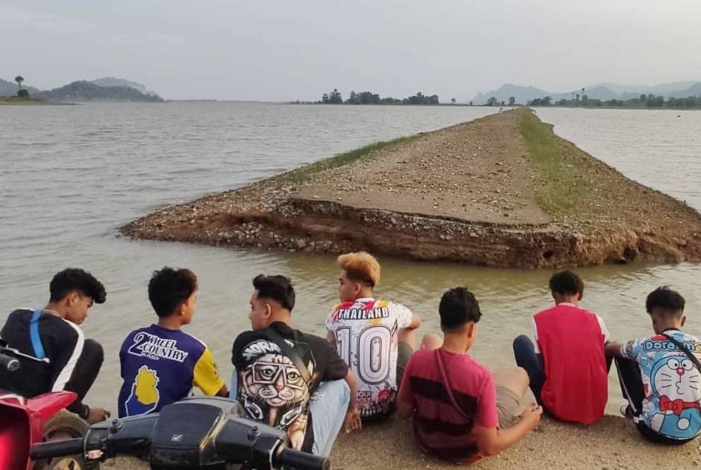 Penduduk setempat tidak melepaskan peluang untuk melihat jalan lama yang 'muncul' selepas Tasik Timah Tasoh di Padang Besar menyusut akibat cuaca panas.