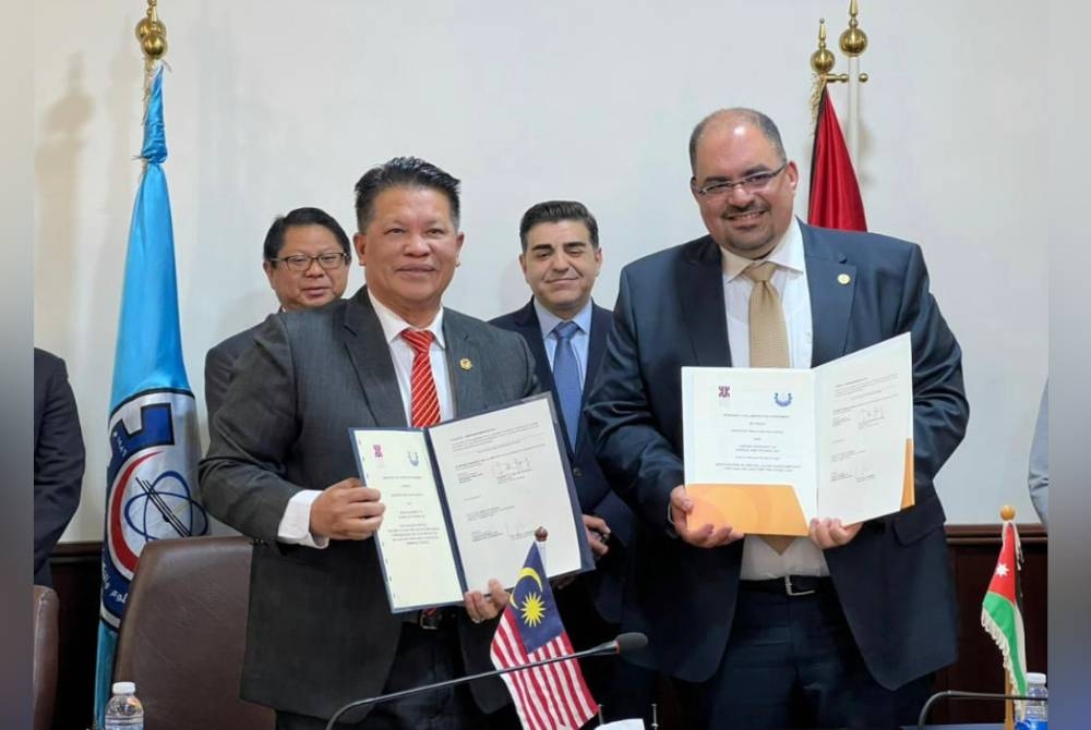 Razli (kiri) dan Khalid (kanan) menunjukkan dokumen MoA antara UMK serta Just. - Foto UMK