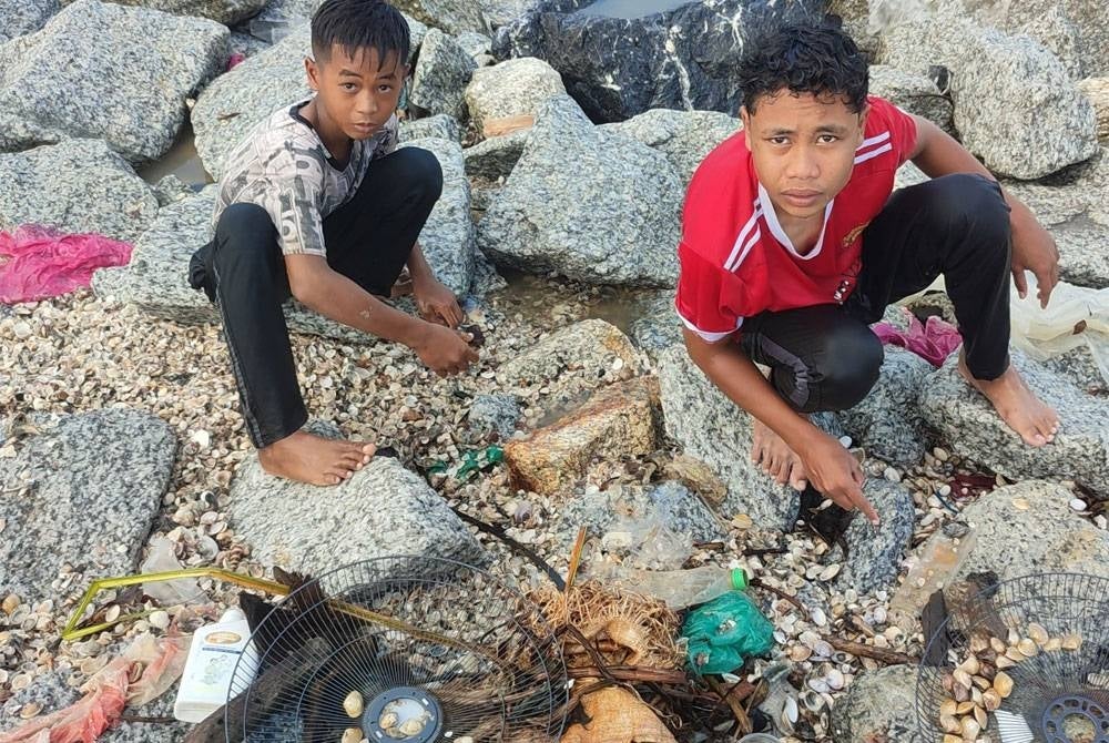 Dua remaja turut mencari kepah di pantai berdekatan Kota Marina, Kuala Kedah.