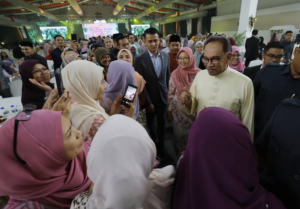 Anwar Ibrahim diiringi Dr Zaliha beramah mesra dengan hadirin semasa hadir pada Majlis Sambutan Hari Raya Aidilfitri Kementerian Kesihatan di Taman Ekspo Pertanian Malaysia Serdang (MAEPS), pada Rabu. - Foto Bernama 