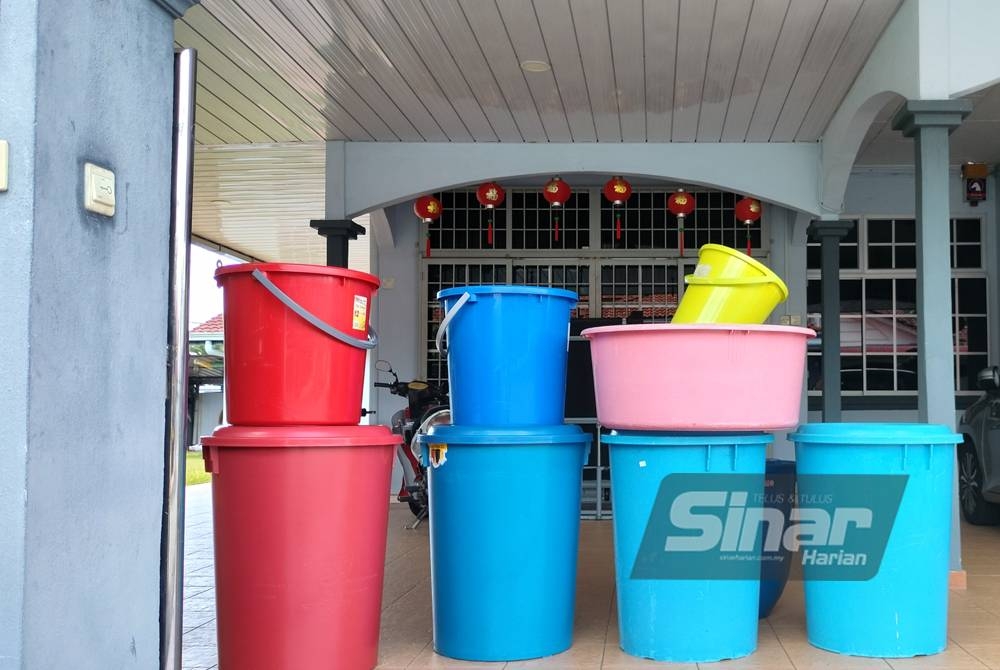 Penduduk Taman Murni menyusun tong kosong bagi menunggu bekalan yang dihantar menggunakan lori setelah empat hari ketiadaan air.