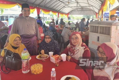 Sallehuddin (berdiri dua dari kiri) beramah mesra bersama tetamu yang hadir pada Majlis Sambutan Aidilfitri PPK Sungai Besar pada Selasa.