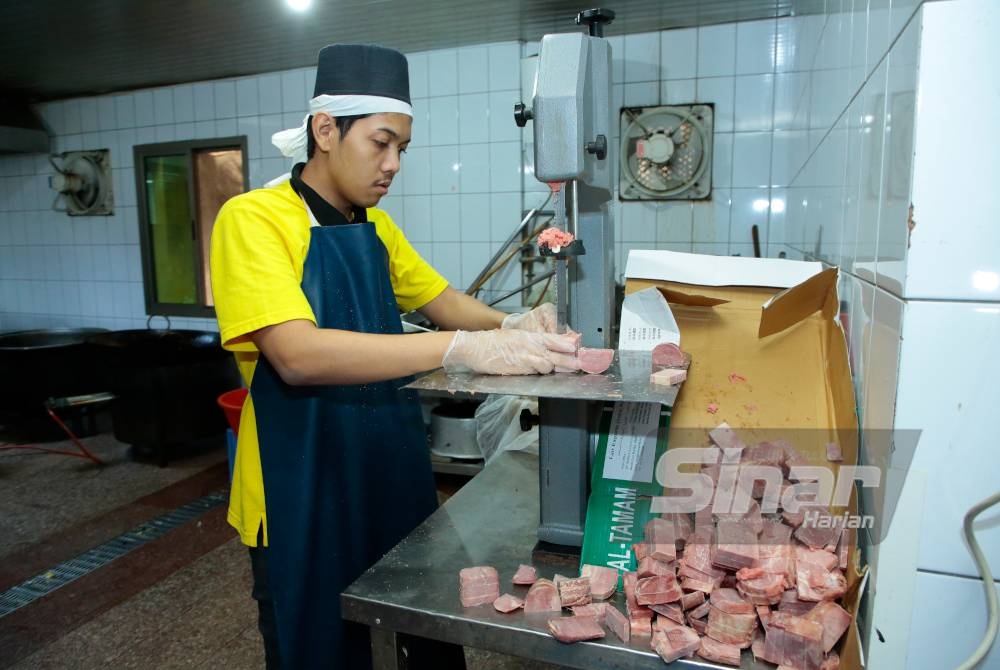 Pembantu, Ibrahim Adnan Fu'ta memotong daging sebagai persediaan masakan.