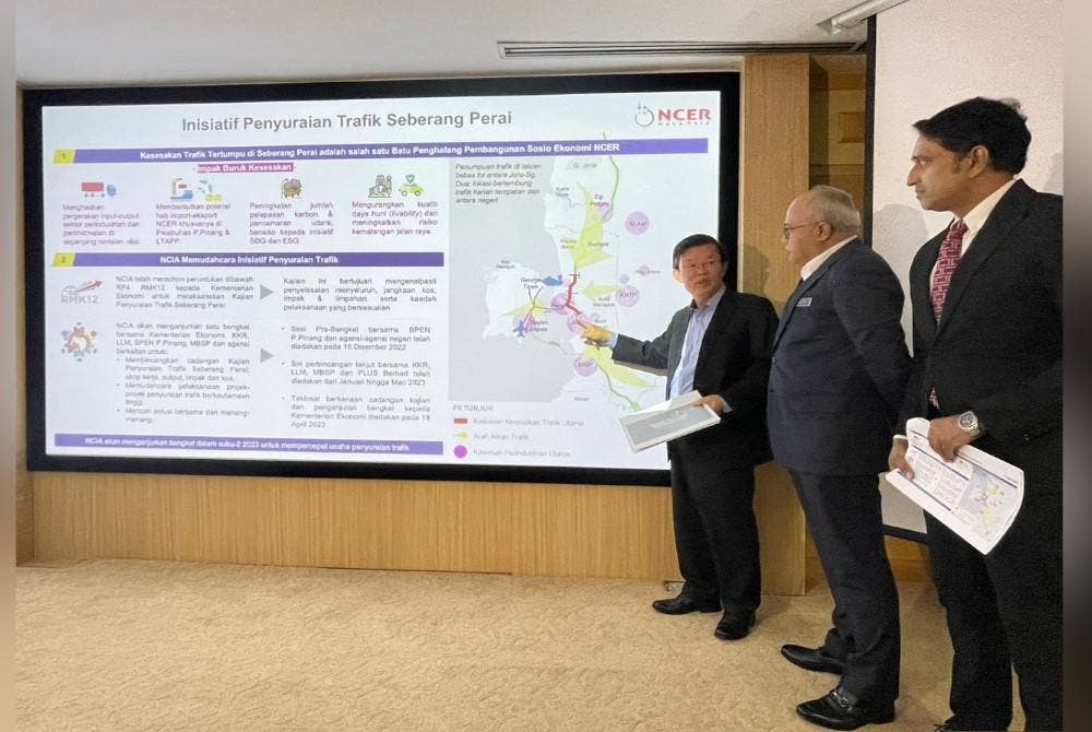 Kon Yeow (kiri) menunjukkan pelan penyuraian trafik di Seberang Perai pada sidang akhbar pada Jumaat.