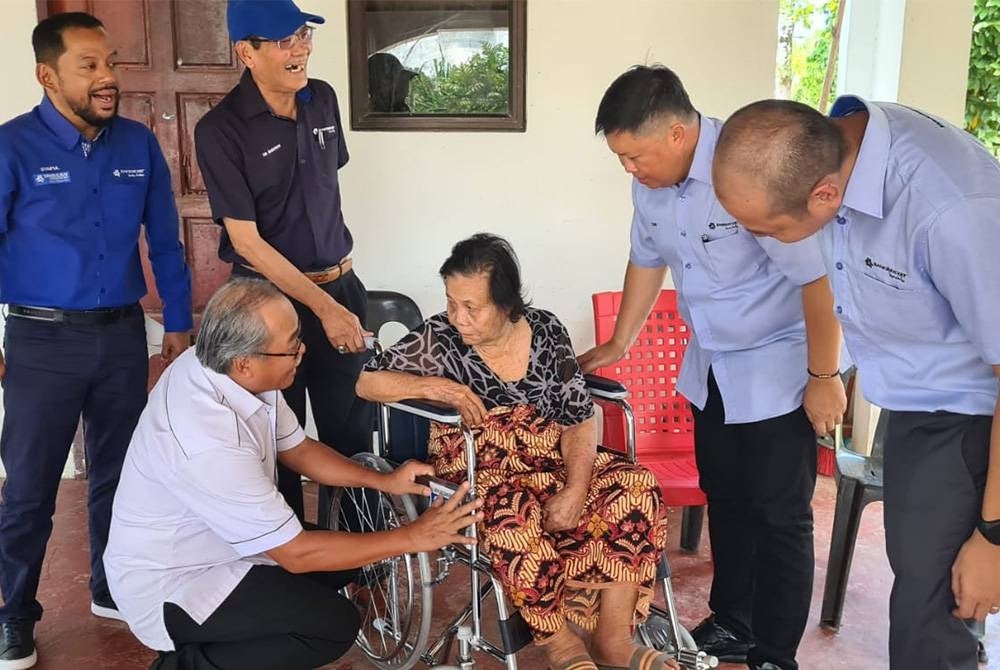 Seorang warga emas menerima kerusi roda daripada pihak YBR.