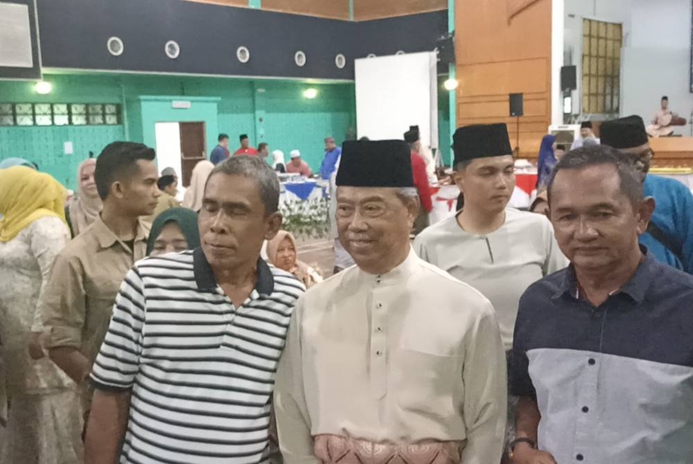 Muhyiddin (tengah) bergambar dengan tetamu yang hadir di Majlis Rumah Terbuka Aidilfitri Parlimen Pagoh dan DUN Bukit Kepong di Kompleks Sukan Pagoh pada Sabtu.