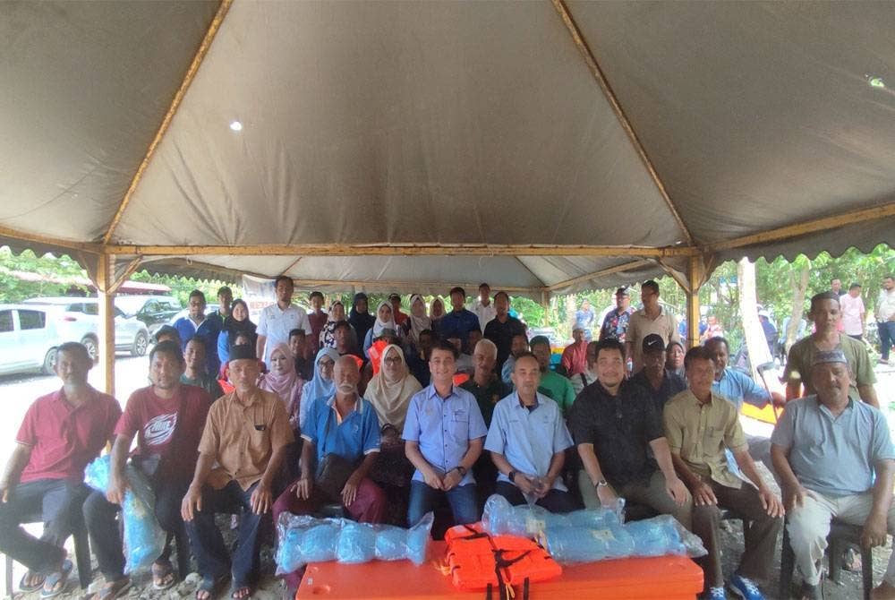 Muhammad Faiz (tengah) bergambar bersama sebahagian nelayan pada Program Sesi Libat Urus Pengerusi LKIM bersama nelayan di Jeti Nelayan Kuala Sedaka, Yan, pada Sabtu.