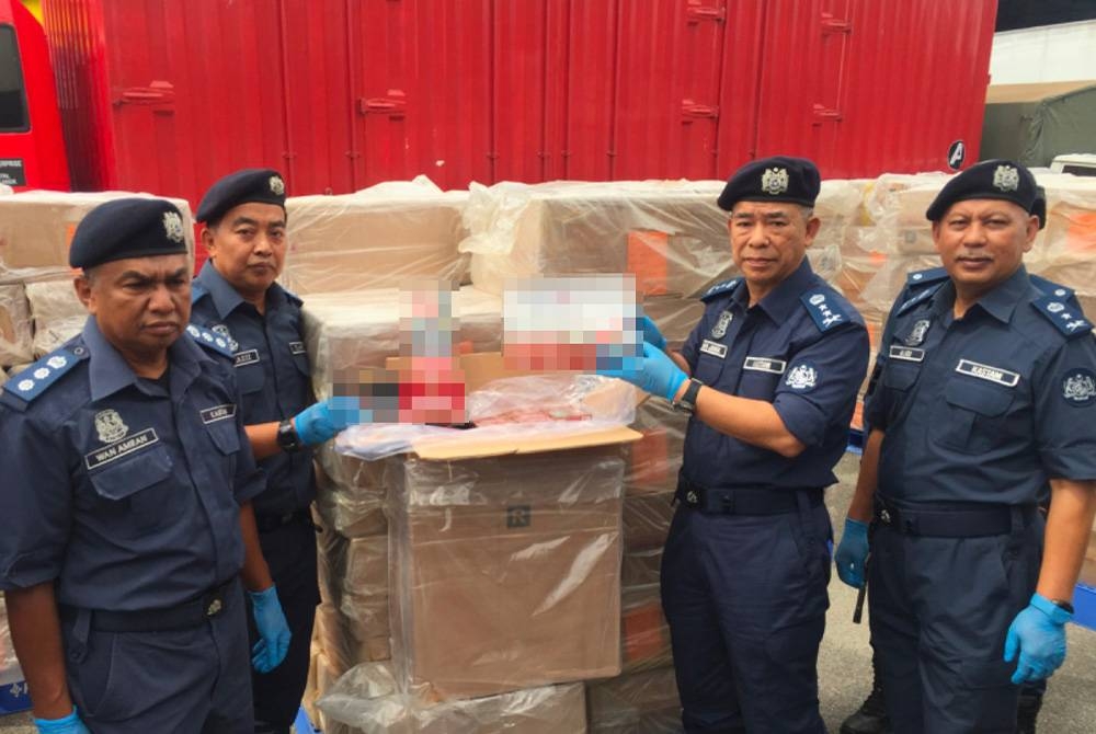 Wan Jamal Abdul Salam (dua dari kanan) menunjukkan rokok di dalam kotak yang dirampas di dalam sebuah lori kurier.