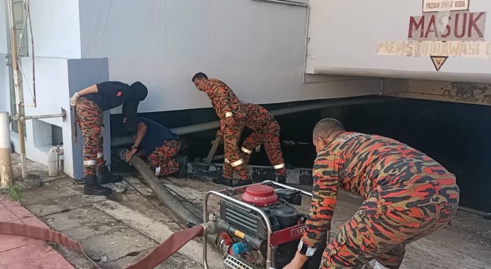 Anggota bomba melakukan kerja-kerja mengepam air.