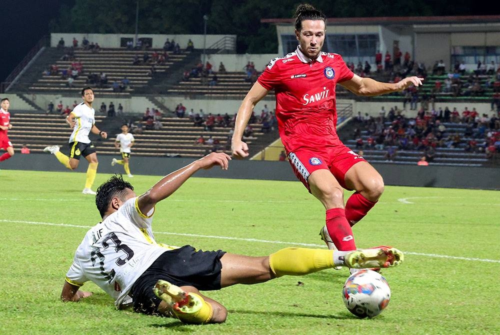 Pemain Perak, Mohammad Alif cuba melepasi kawalan pertahanan Sabah dalam saingan Liga Super di Stadium Likas pada Selasa. - Foto Bernama