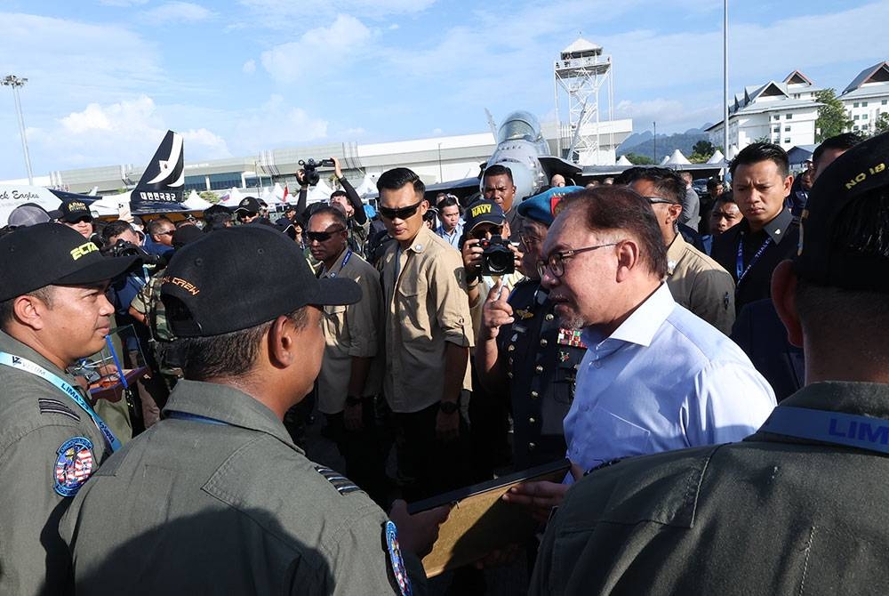 Perdana Menteri Datuk Seri Anwar Ibrahim (kanan) beramah mesra dengan juruterbang ketika meninjau Pameran Maritim dan Aeroangkasa Antarabangsa Langkawi (LIMA'23) di Pusat Pameran Antarabangsa Langkawi (MIEC) hari ini.