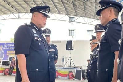 Kok Chin (kiri) memeriksa perbarisan ketika Majlis Perhimpunan Bulanan dan Amanat Ketua Polis Pulau Pinang di IPK Pulau Pinang pada Rabu.