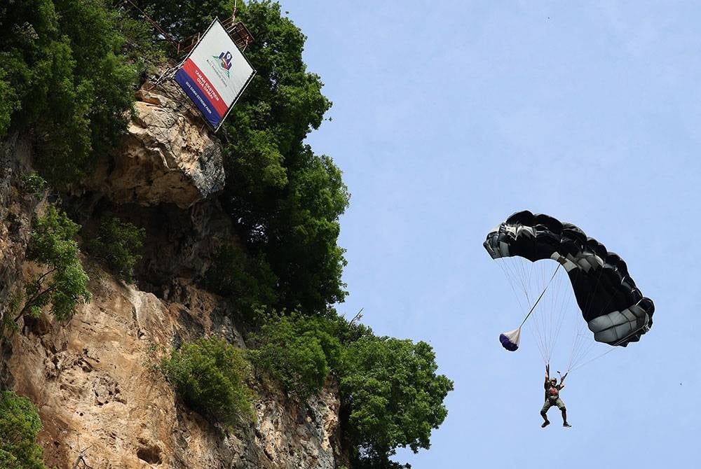 Aksi aktiviti payung terjun oleh penerjun profesional, Akmal Jamal Hassan berlatarbelakangkan Bukit Lembah Damai, Batu Caves sempena Program Kembara Media 2023 anjuran Jabatan Penerangan Malaysia, Kementerian Komunikasi dan Digital (KKD) di Selangor dan Negeri Sembilan baru-baru ini.