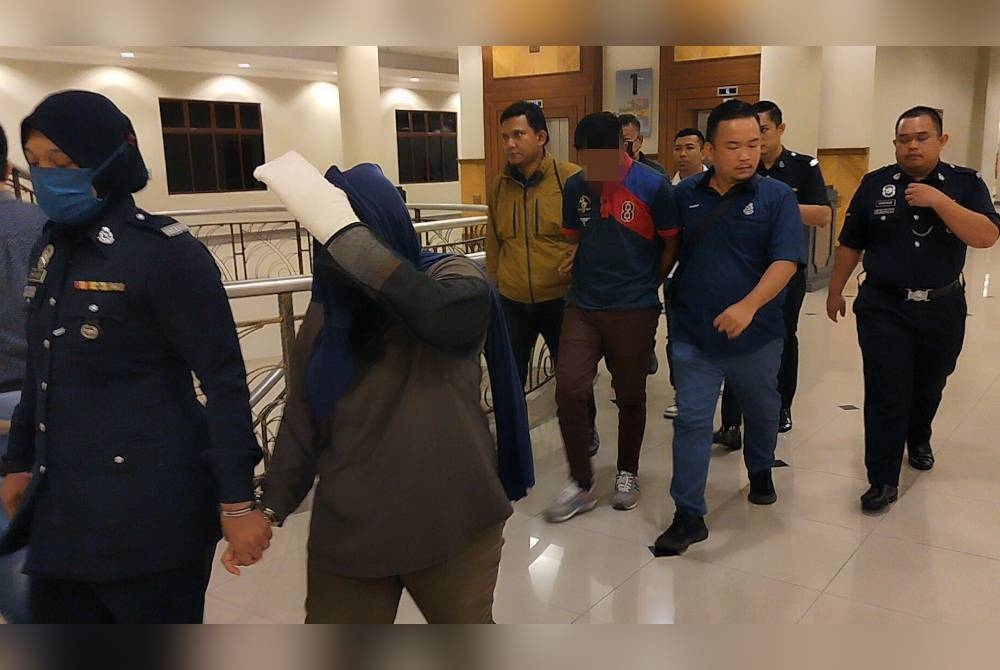 Tertuduh, Nur Syafiqah (depan, kanan) dan suaminya, Noor Aliff Redzwan (belakang, dua dari kanan) diiringi anggota polis keluar dari ruang mahkamah selepas selesai sebutan kes mereka pada Khamis.