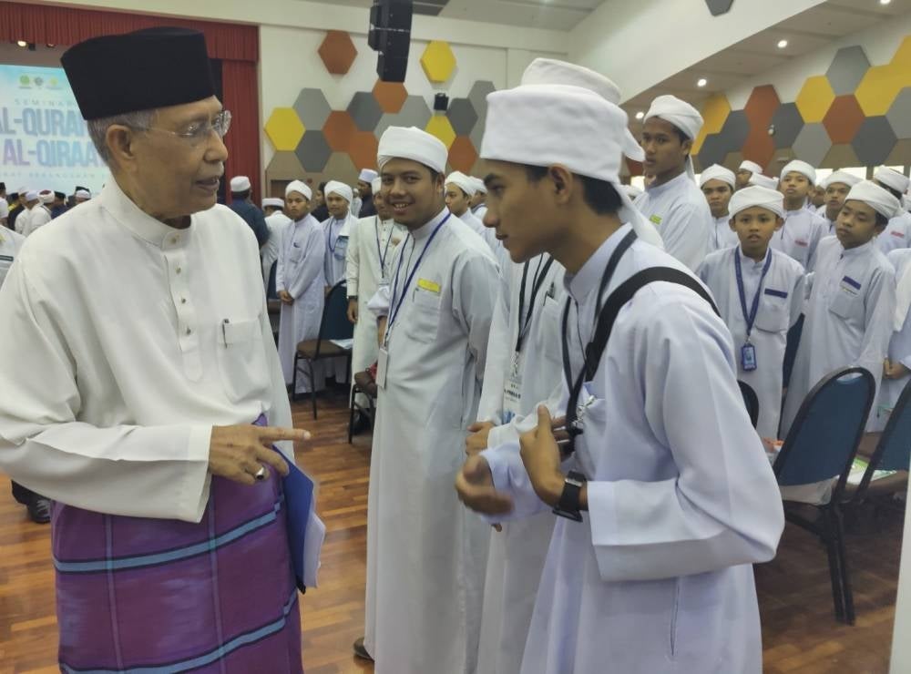 Abdul Aziz (kiri) beramah-mesra dengan pelajar tahfiz semasa Program Seminar Al-Quran dan Al-Qiraat Peringkat Kebangsaan 2023 di Dewan Berlian UiTM Puncak Alam di sini pada Khamis.