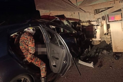 Anggota bomba cuba mengeluarkan mangsa yang tersepit dalam kereta Perodua Axia yang terlibat dalam kemalangan berkenaan. - Foto ihsan Bomba Kota Tinggi
