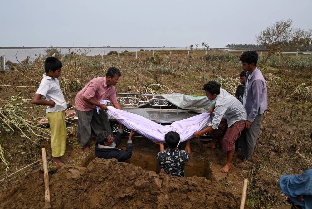 Pelarian etnik Rohingya mengebumikan saudara mereka yang menjadi mangsa Siklon Mocha di negeri Rakhine. - AFP