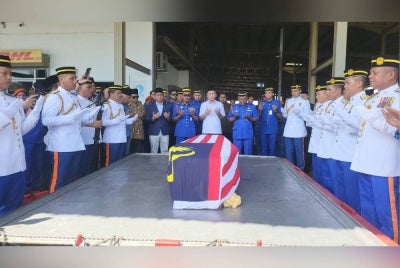 Jenazah Awang Askandar disambut oleh ahli keluarga Allahyarham dan pasukan APM di MAS Kargo, Kota Kinabalu.