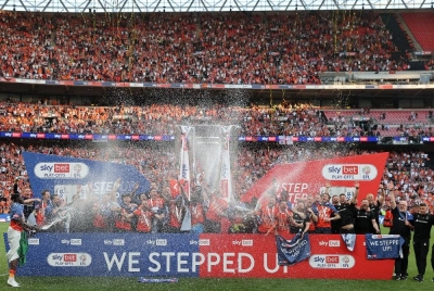 Tonggak pertahanan Luton Town, Sonny Bradley memegang trofi ketika pemain meraikan kejayaan memenangi penentuan sepakan penalti perlawanan akhir play-off Liga Kejuaraan menentang Coventry City di Stadium Wembley. - Foto AFP