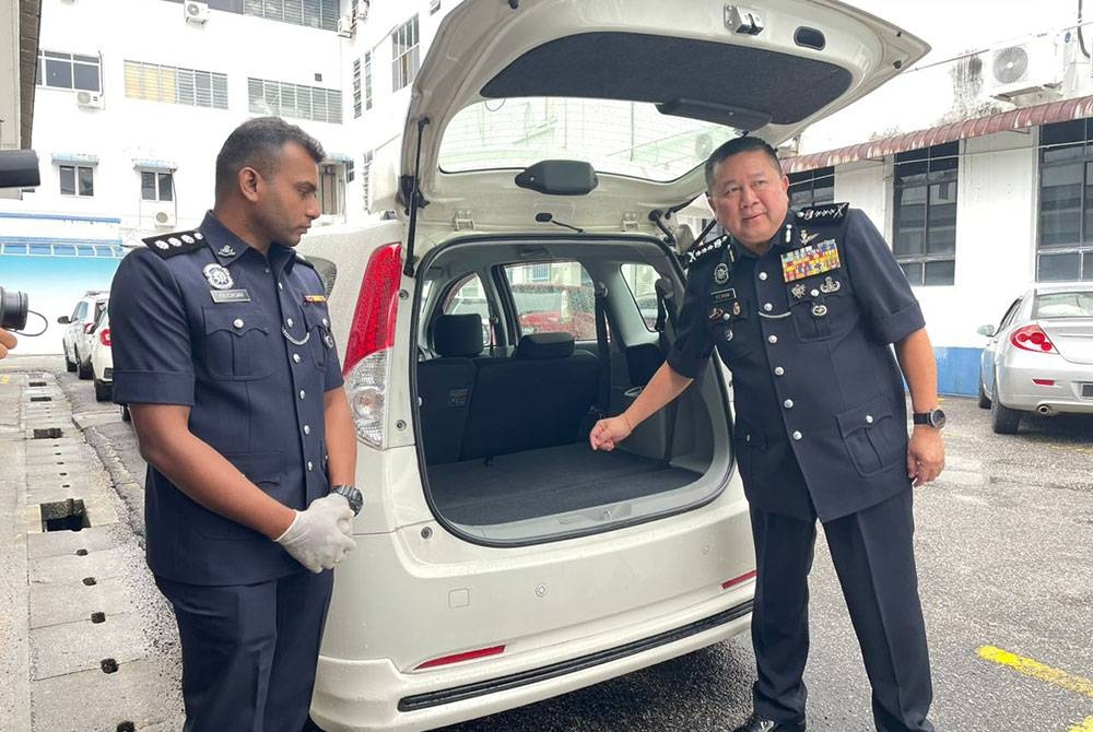 Kok Chin (kanan) menunjukkan kereta yang digunakan suspek untuk menyembunyikan dadah.