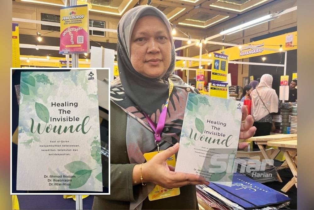 Roziyana menunjukkan buku 'Healing The Invisible Wound' yang dijual di reruai Kumpulan Karangkraf sempena PBAKL di WTC.