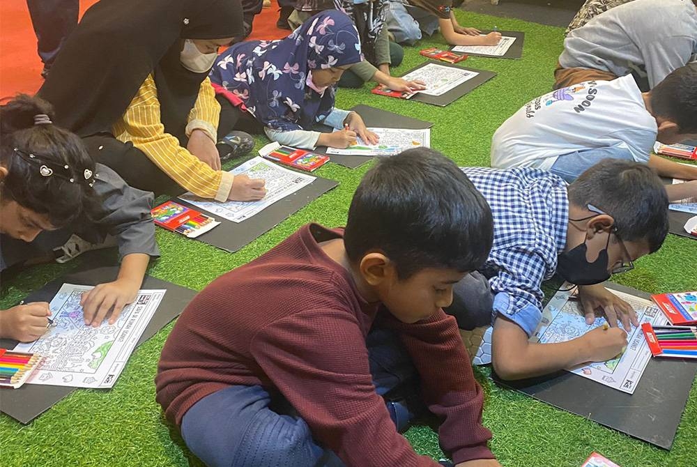 Kanak-kanak menunjukkan bakat mewarna masing-masing pada pertandingan mewarna di reruai Karangkraf.