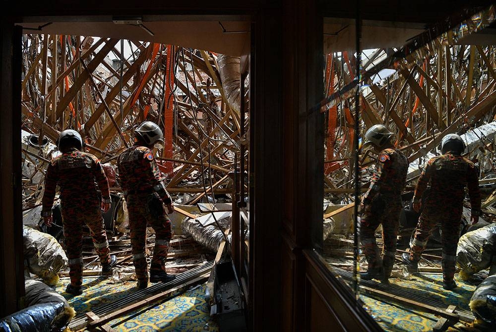 Anggota Bomba dan Penyelamat memeriksa runtuhan bumbung Dewan Besar Institut Kefahaman Islam Antarabangsa (IKIM) di Langgak Tunku, Jalan Tuanku Abdul Halim yang berlaku 11.55 pagi semalam ketika tinjauan foto Bernama hari ini.