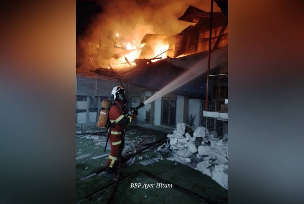 Anggota bomba memadam kebakaran bangunan STI, Parit Raja pada malam Rabu. - Foto JBPM