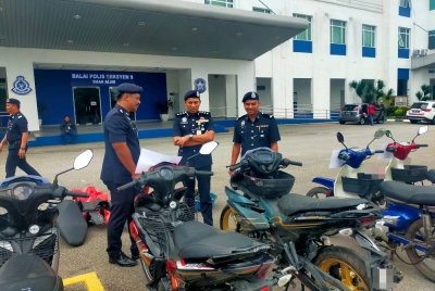 Mohd Iqbal (tengah) melihat motosikal curi yang berjaya ditemukan selepas penahanan sembilan suspek daripada Geng Daus dan Geng Hafiz selepas sidang akhbar di IPD Shah Alam pada Jumaat.