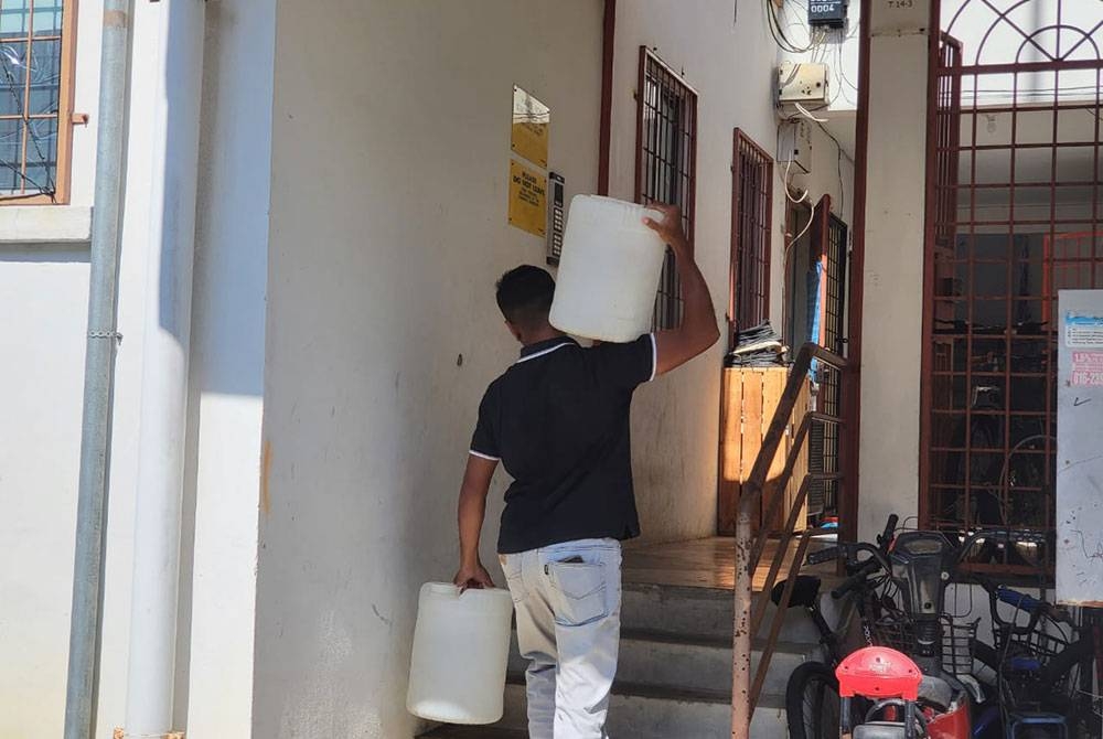 Penduduk yang tinggal di tingkat atas perumahan berkenaan terpaksa mengangkat air menggunakan gelen untuk mengangkat air dari bawah.