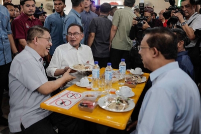 Perdana Menteri Datuk Seri Anwar Ibrahim meluangkan masa untuk menikmati juadah makanan bersama Ketua Setiausaha Negara Tan Sri Mohd Zuki Ali (kanan) dan Datuk Bandar Kuala Lumpur Datuk Kamarulzaman Mat Salleh (kiri) pada majlis perasmian D'Anjung Selera Madani Jalan Jujur, Bandar Tun Razak hari ini.
