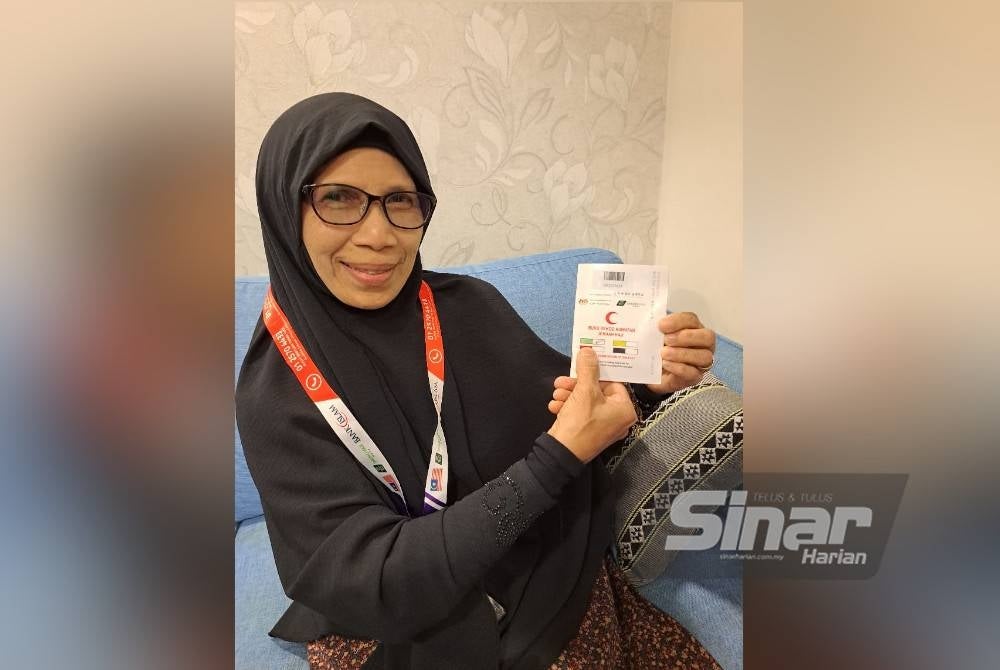 Hafizah menunjukkan buku kesihatan beliau bertanda hijau yang beerti tiada penyakit kronik.