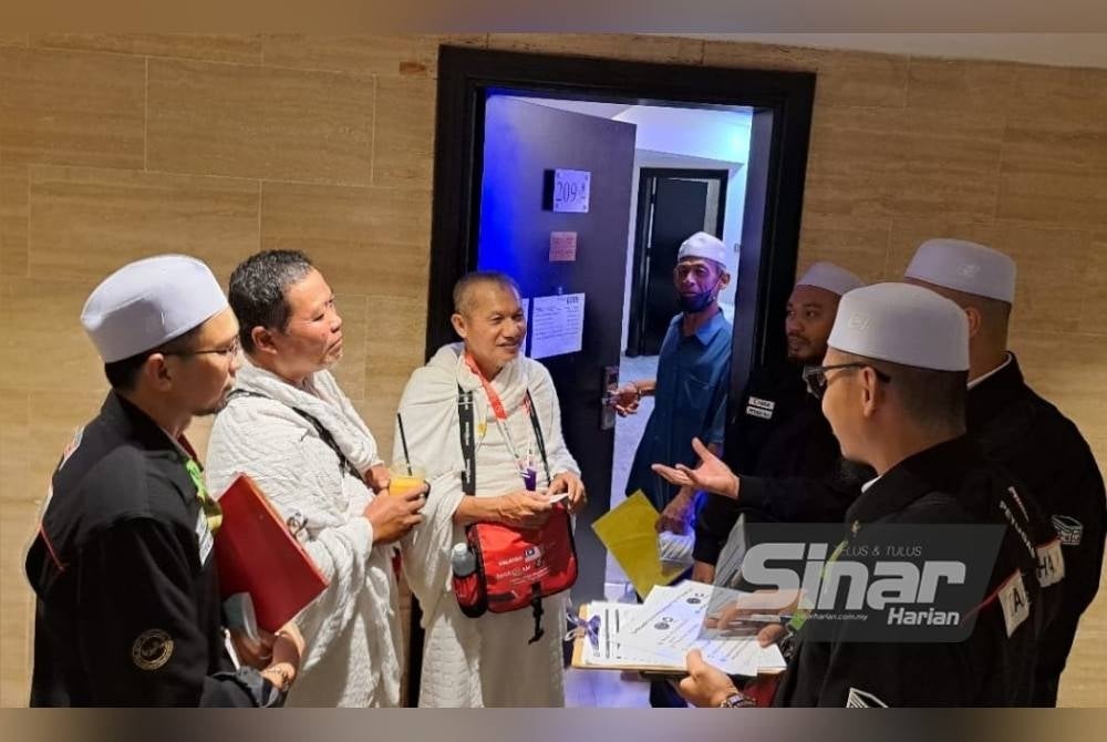 Petugas kesihatan memberi penerangan kepada jemaah haji lelaki.