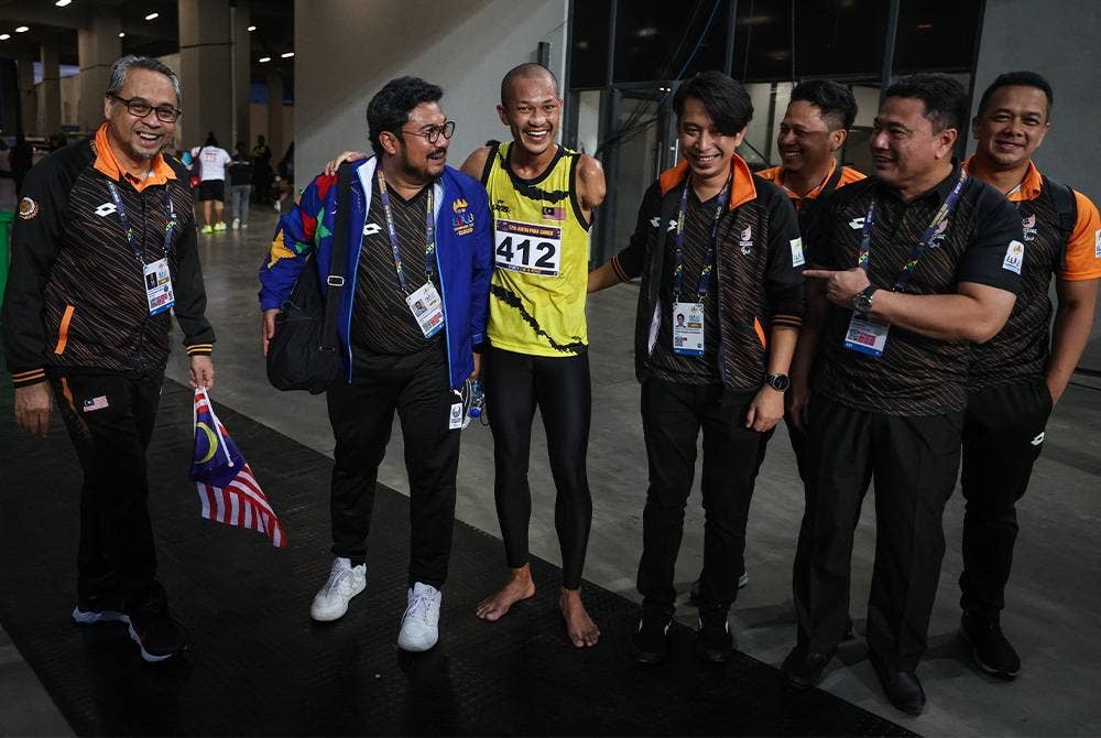 Timbalan Menteri Belia dan Sukan, Adam Adli Abd Halim (empat dari kiri) dan Presiden Majlis Paralimpik Malaysia (MPM), Datuk Seri Megat D Shahriman Zaharudin (dua dari kiri) beramah mesra bersama Muhamad Ashraf (tiga dari kiri) ketika tiba di Kemboja hari ini. - Foto Bernama